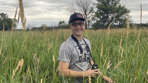 photo of Hayden Hoos in field doing research