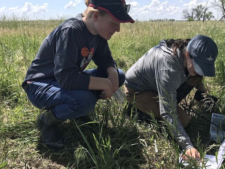 Abi Schoup and Dr. Elizabeth VanWromer performing field research on frogs